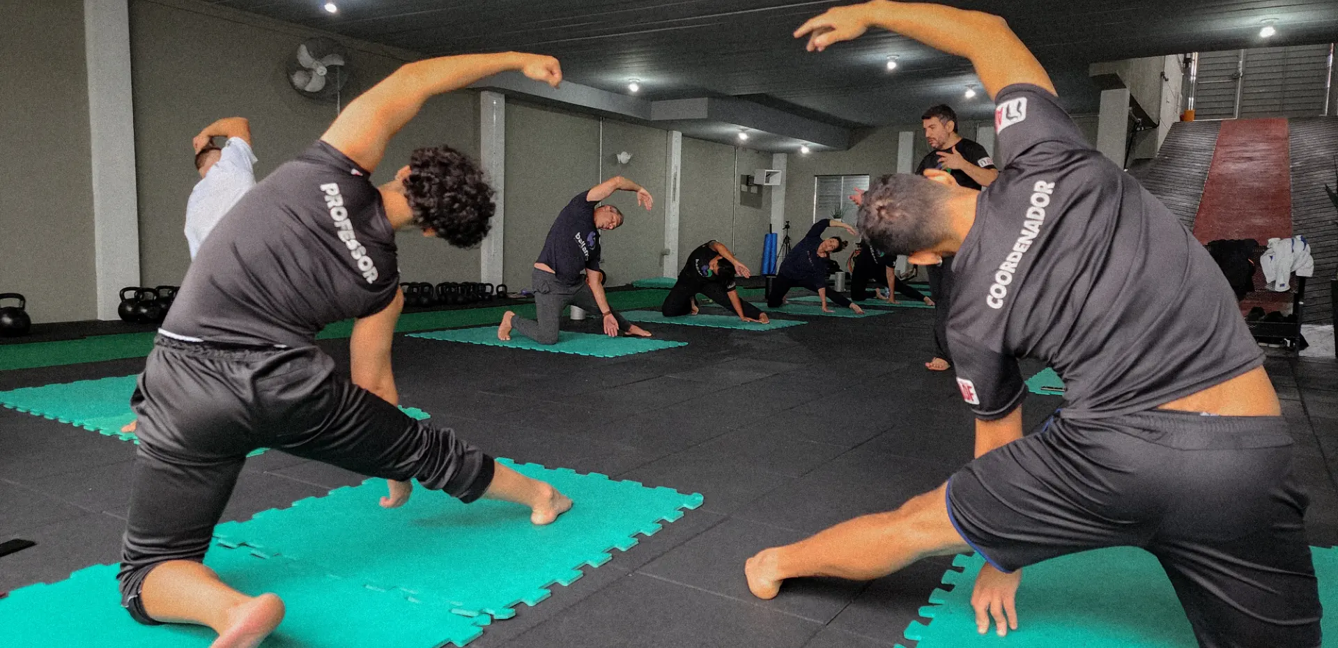 Turma do Ballance Studio em alongamento durante a aula, sobre os tatames